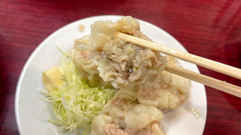 箸で持ち上げた長崎亭のシュウマイと付け合わせキャベツ