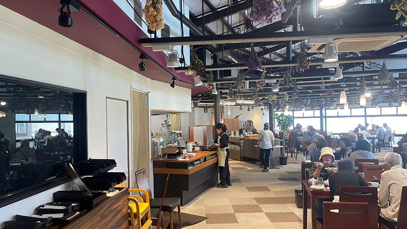天井が高く明るいおみたまキッチンの店内とランチ客の様子