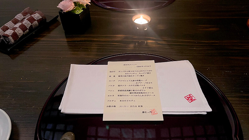 キャンドルと花と品書きが置かれた藤右ェ門 栄の個室テーブル