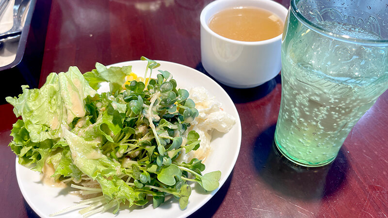 サラダとスープと冷たいドリンクを並べたAランチのセット
