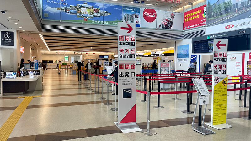茨城空港ターミナル内の出発口と案内表示が見える風景
