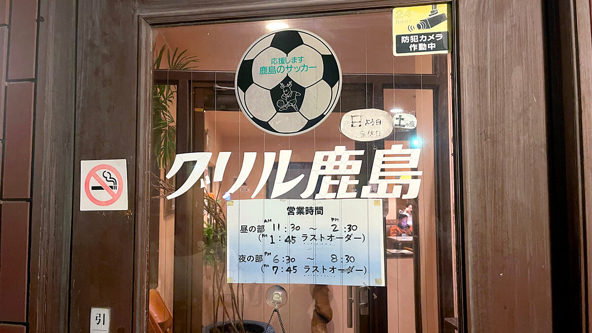 グリル鹿島の入口に掲げられたサッカーボールと店名