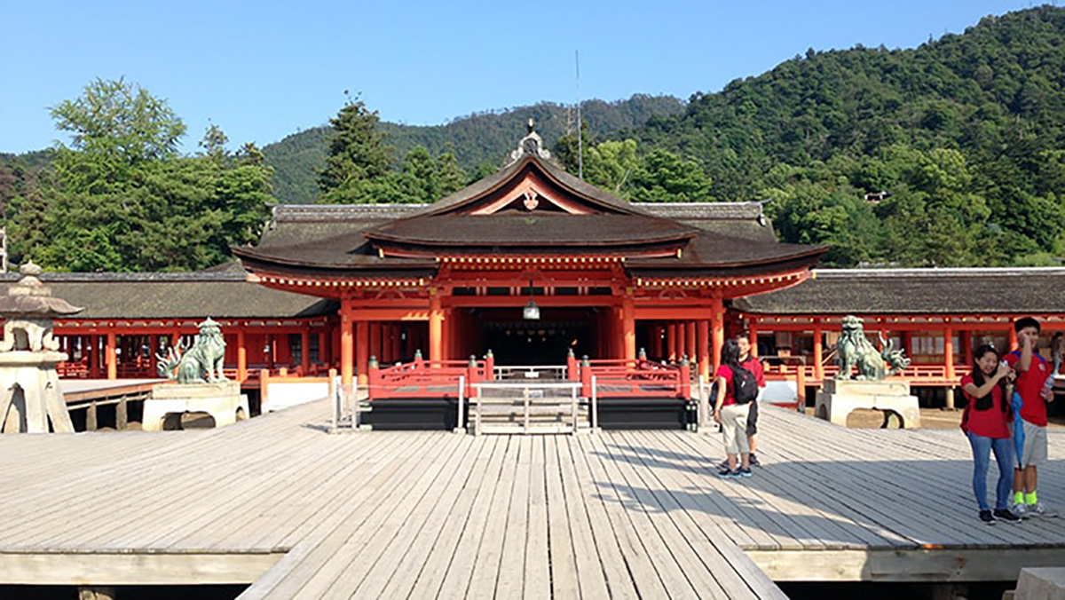 嚴島神社の朱塗りの社殿と背後に広がる宮島の山