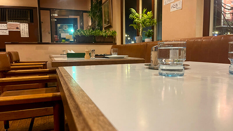 白いテーブルとソファ席が並ぶグリル鹿島の落ち着いた店内