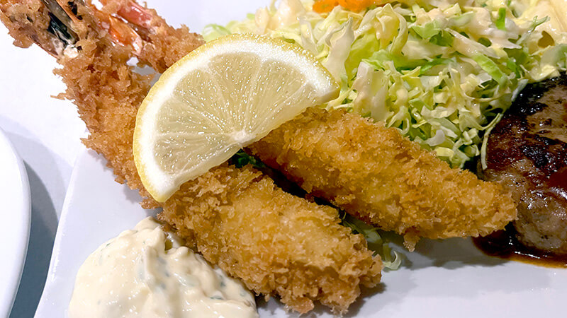 薄衣で揚げられたグリル鹿島のエビフライとタルタルソース