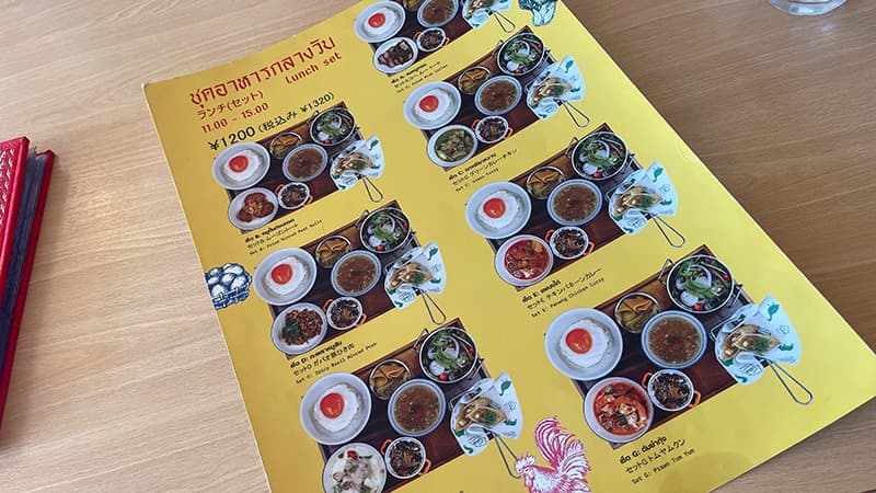 黄色い台紙に写真が並ぶGINGER FARM KITCHENのランチセットメニュー