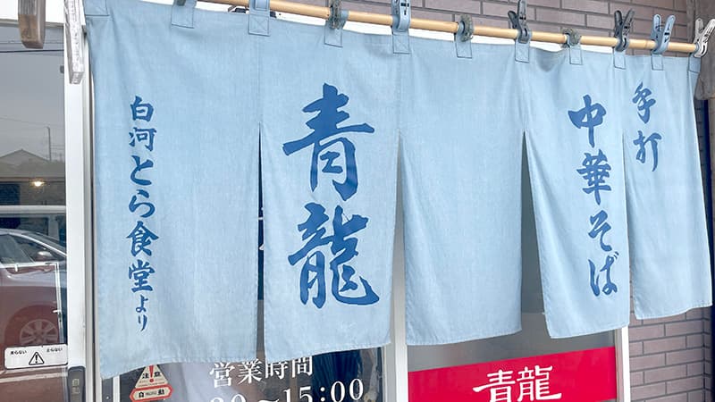 白河とら食堂から贈られた暖簾が掛かる鹿嶋のらーめん青龍