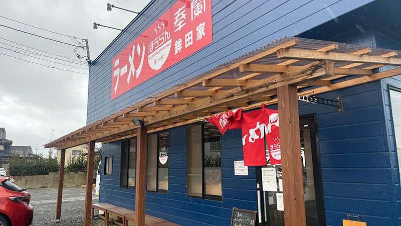 国道51号沿いに建つラーメン奉蘭鉾田家の青い外観と赤い看板