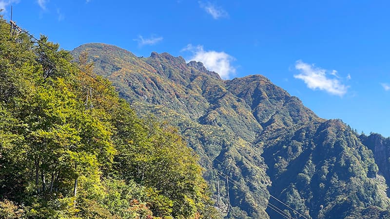 青空の下にギザギザとした岩峰が連なる八海山の八ツ峰