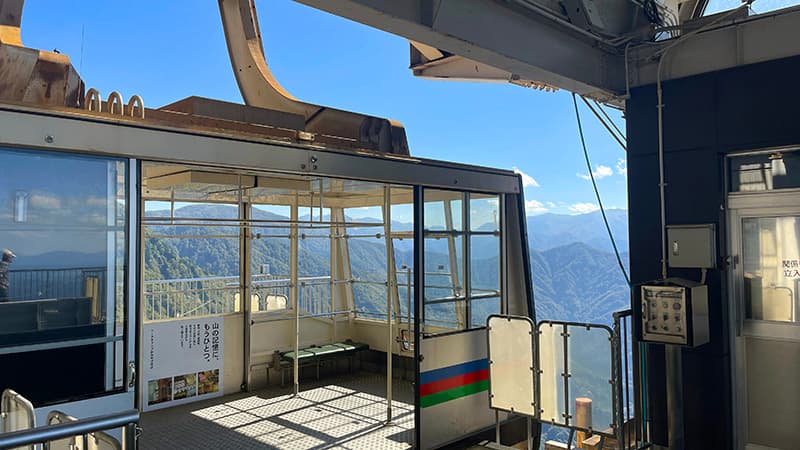 八海山ロープウェーの山頂駅に到着したゴンドラと眼下に広がる山並み